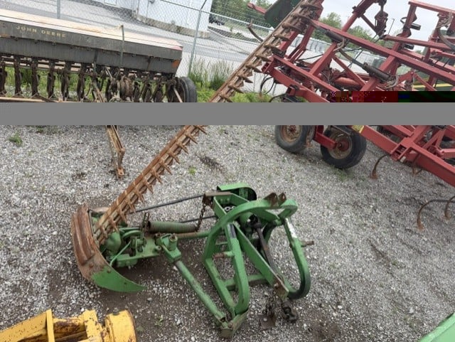 Green three-point hitch sickle bar mower on gravel lot